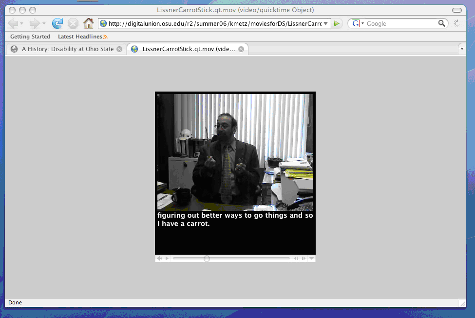 screenshot of frame captioned movie playing in macintosh firefox browser: image of man holding a carrot, captioned 'figuring out better ways to go things and so I have a carrot' — misspelling in caption