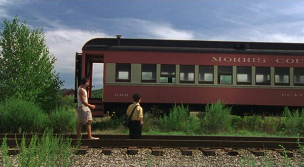 A scene shot at Fin's height and emphasizing horizontal elements. Fin and Joe are shown standing by a train.
