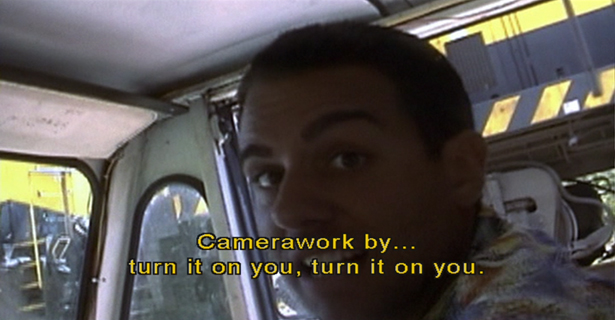 Photo of Joe behind the steering wheel of his truck. Text on photo says -- Camerawork by, turn it on you, turn it on you.