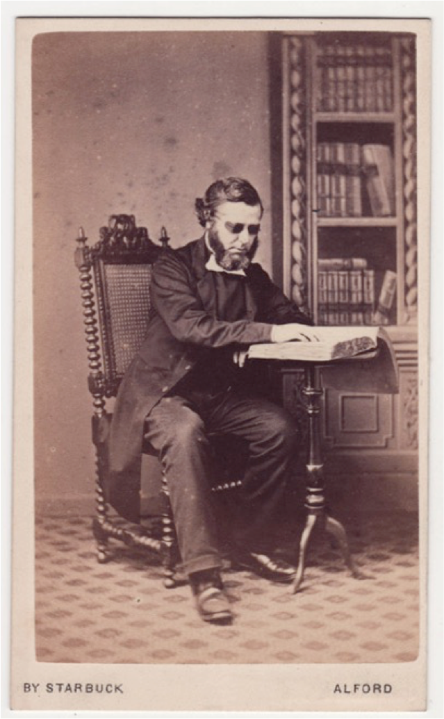 Unidentified man reading at a desk. More description below.