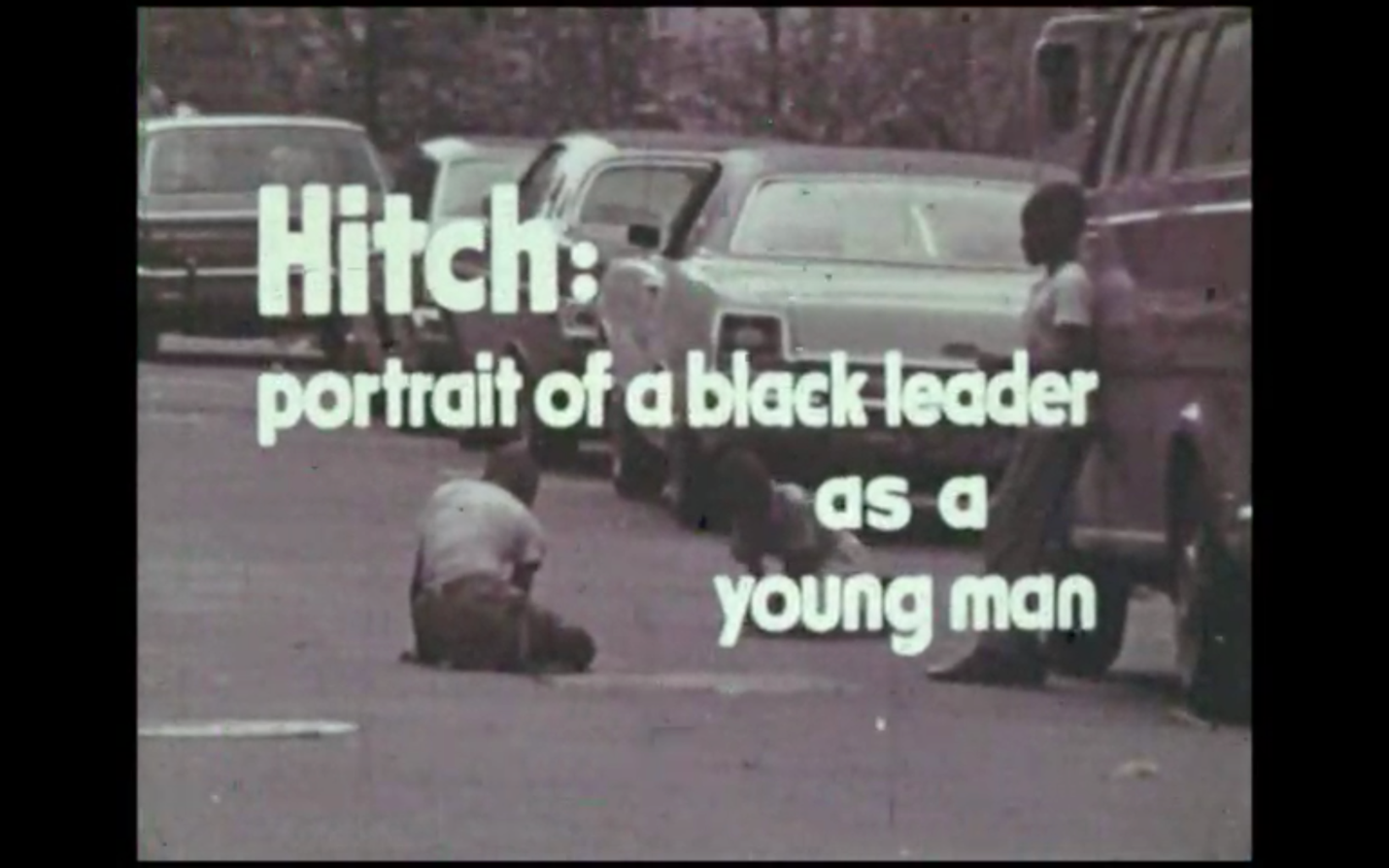 A still image of the title frame from <em>Hitch: Portrait of the Black Leader as a Young Man</em>. The title words appear in white font over an exterior scene of three young Black children playing on the macadam of a city street. A line of parked cars appears behind them and in the background. The children appear to be playing jacks or dice. The image is used with permission of Oren Jacoby.