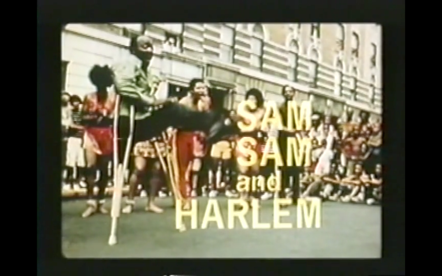 A still image of the title frame of <em>Sam, Sam in Harlem</em>. The title words appear over an exterior scene, shot in color film, of a street celebration. A large crowd, some people seated and some standing, watches dancers, among them a man with one leg who dances while supported by two crutches. In this still, his leg is aloft, seemingly at the apex of his kick's arc. The image is used with permission of Oren Jacoby.